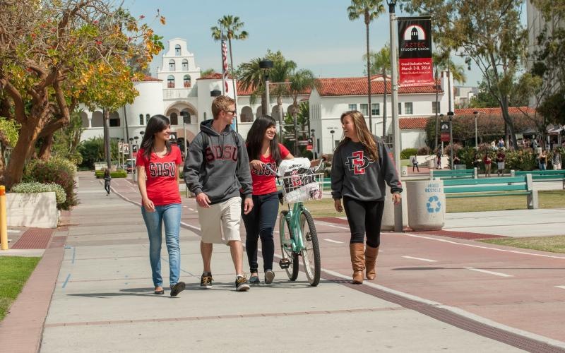 a group of people walking on a sidewalk