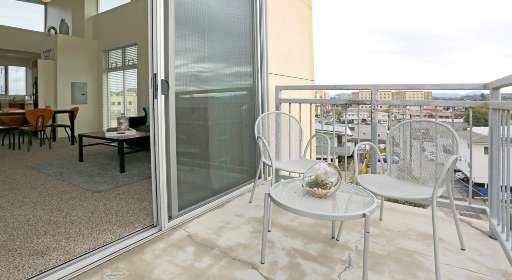 Settle into comfort at Paseo Place a room with a table chairs and a glass door